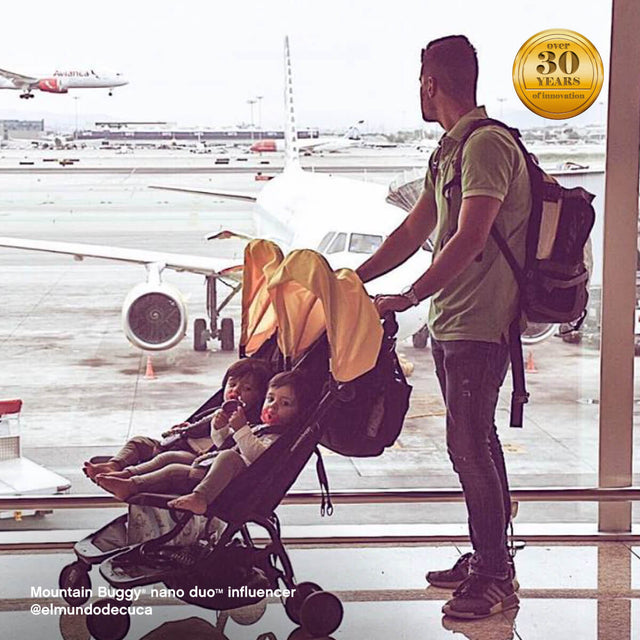 dad with two toddlers in nano duo stroller, waiting at the airport - Mountain Buggy nano duo™ influencer @elmundodecuca